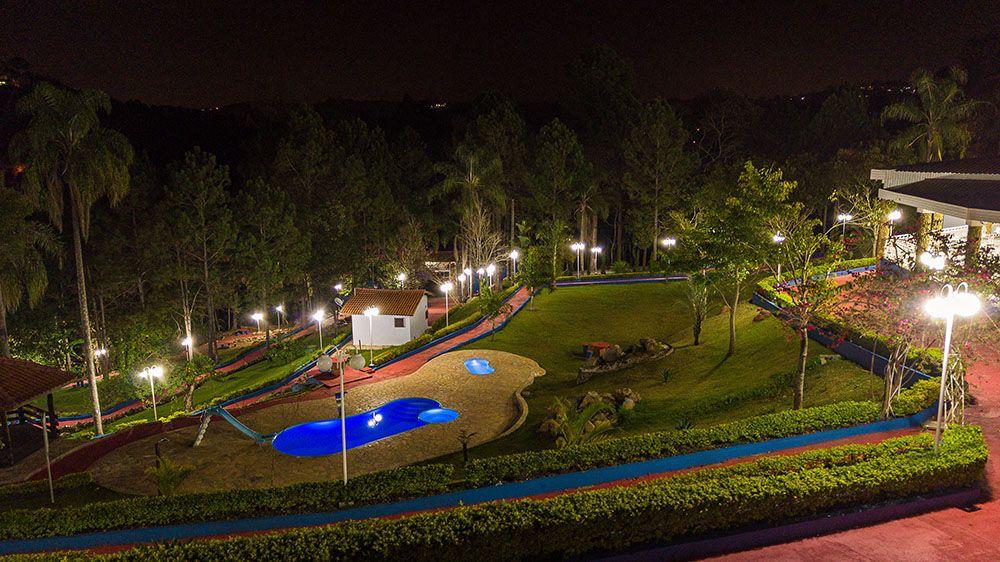 Jardins e piscina iluminados à noite — Unidade 04